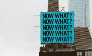 שלט NOW WHAT המסמל התלבטות וסדרי עדיפויות בחיים