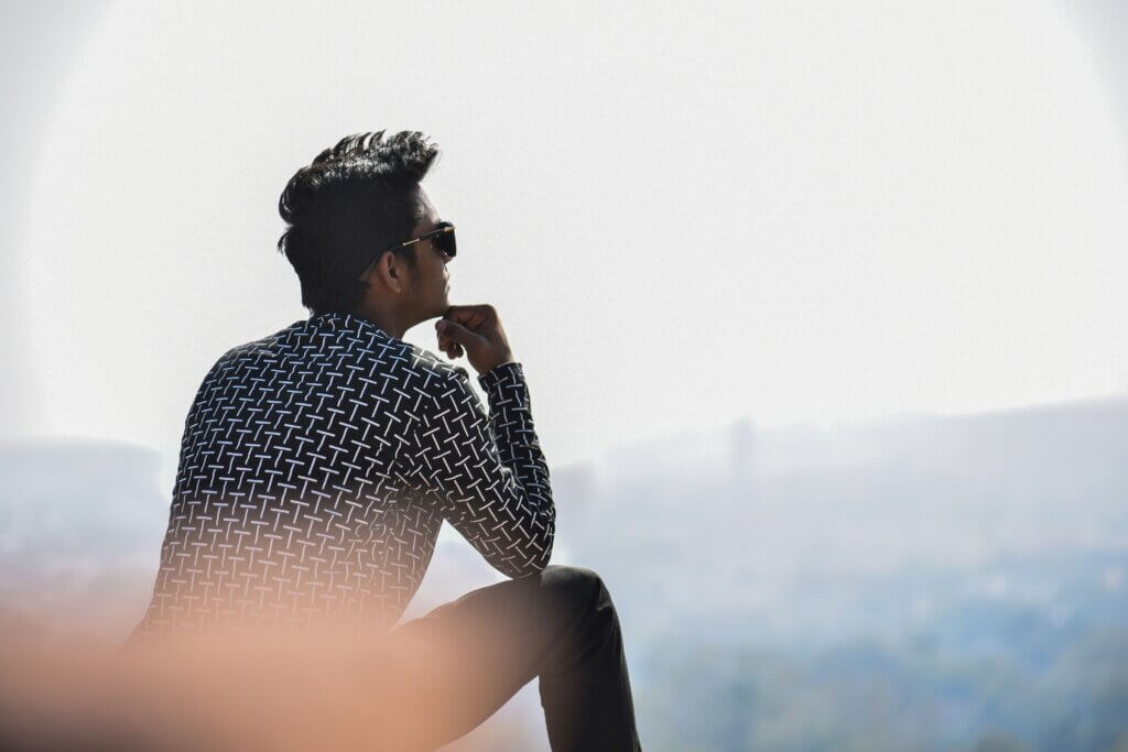 אדם חושב בשקט ומתבונן קדימה – התמודדות עם מחשבות טורדניות והתמקדות בהמשך